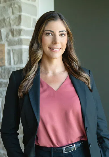 Attorney Professional Headshot Profile Professional portrait of a female attorney with long brown hair, wearing a pink top and a dark blazer.